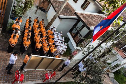 an overhead view of a choir in orange uniforms at Sala Baï Hotel & Restaurant School in Siem Reap