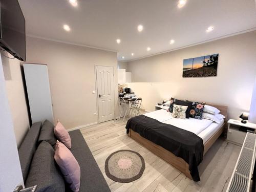 a bedroom with a bed and a couch at Milano Vendégház in Bakonybél