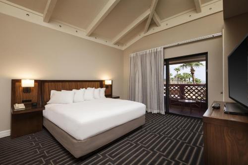 a hotel room with a large bed and a television at Hilton Phoenix Tapatio Cliffs Resort in Phoenix