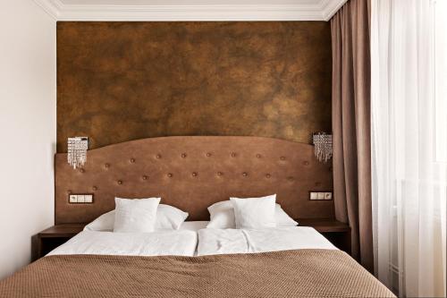 a bedroom with a large bed with a brown headboard at Hotel Sylwia in Sośnicowice