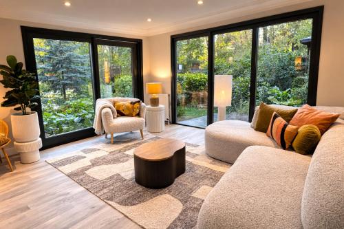 a living room with a couch and a table at StayatSas Pippa grote omheinde tuin in het bos aan grote vijver, zwembad en restaurant op het park, stijlvol ingericht,veel privacy in Doornspijk