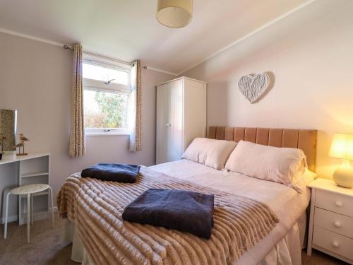 a bedroom with a bed with two pillows on it at Chalet 23 Erw Porthor in Tywyn
