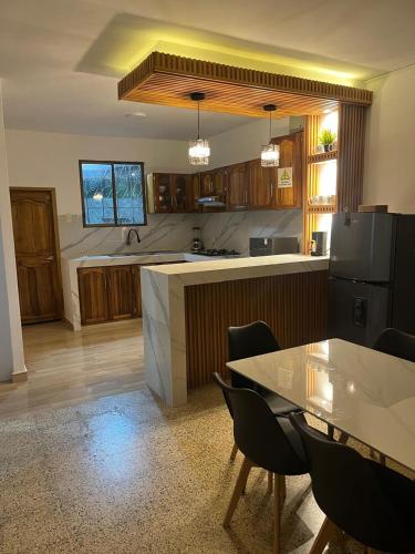 a kitchen with a table and a black refrigerator at Dulce Hogar in Manta