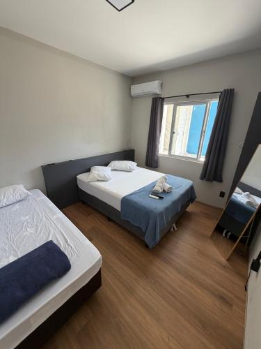 a bedroom with two beds and a window at Esquina 8 Apart in São José