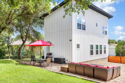 a patio with a table and a red umbrella at Pitch Perfect in Canyon Lake
