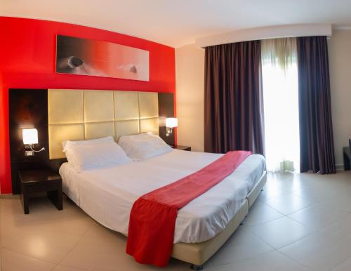a bedroom with a large bed with a red wall at Rama Palace Hotel in Casalnuovo di Napoli