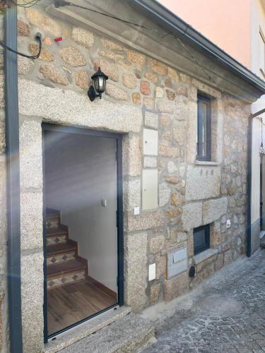 a stone building with a door and a stairway at Casa de Girabolhos in Girabolhos