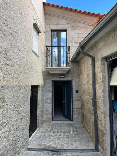 a brick building with a door and a balcony at Casa de Girabolhos in Girabolhos