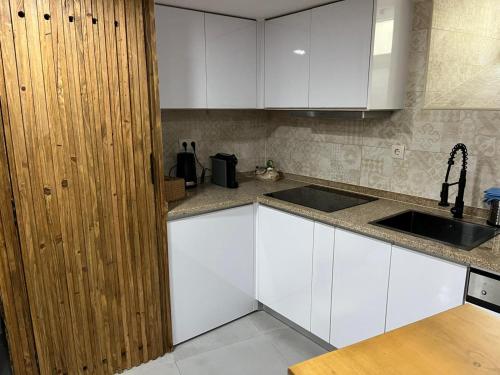 a kitchen with white cabinets and a sink at Casa de Girabolhos in Girabolhos