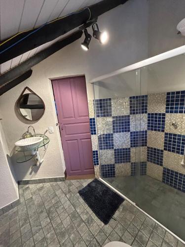 a bathroom with a purple door and a sink at Chalé - Refúgio Serra das Águas in Araras Petropolis