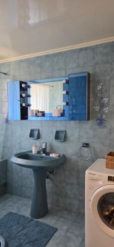 a bathroom with a sink and a washing machine at Sounio Garden Retreat in Panayía