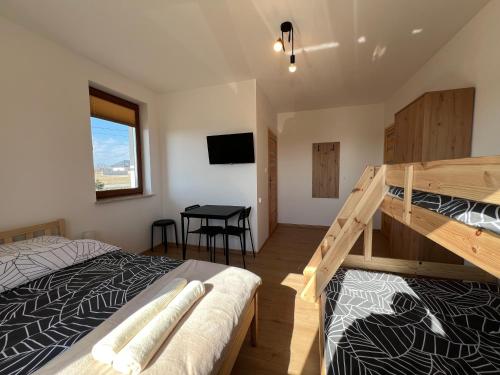 a bedroom with two bunk beds and a table at Noclegi Widokowa Przystań in Krajno Pierwsze