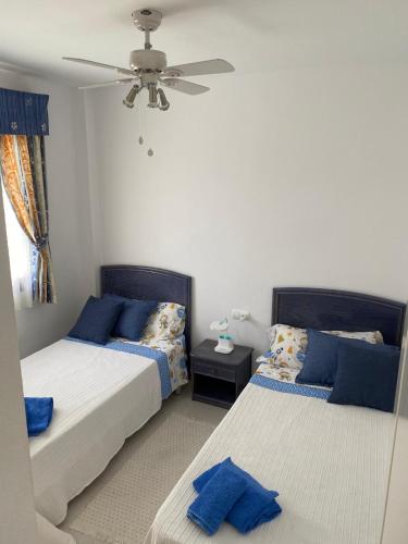 a bedroom with two beds and a ceiling fan at EL DESCANSO in Calpe