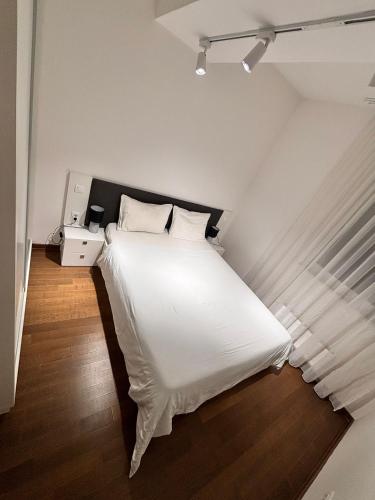 a bedroom with a white bed with a black headboard at Tower II in Banja Luka