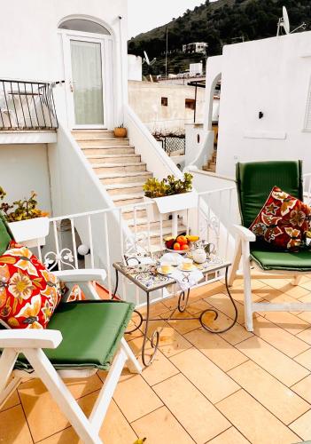 a balcony with chairs and a table with fruit on it at Casa Maddy Anacapri Yellow Room in Anacapri