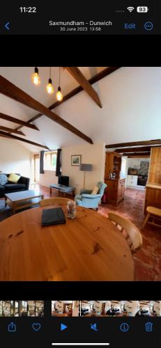 a view of a living room with a large wooden table at Avocet Cottage in Dunwich