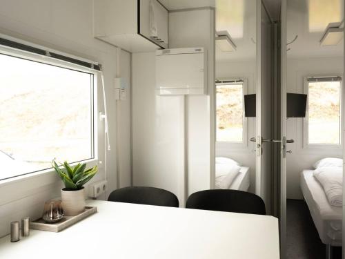 a room with a table and two chairs and a bedroom at Budget Mobile House in Faroe Islands in Strendur