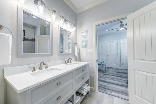 a white bathroom with a sink and a mirror at The Flamingo Place in Rockport
