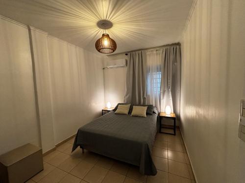 a bedroom with a bed with two lamps on it at Casa serena apart in Paraná
