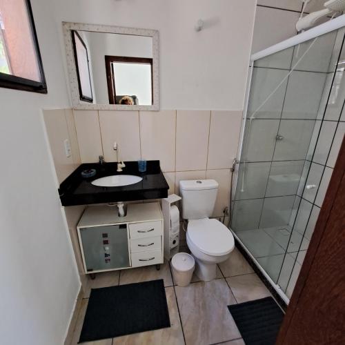 a bathroom with a toilet and a sink and a shower at Charmosa suíte de Tucuns. in Búzios