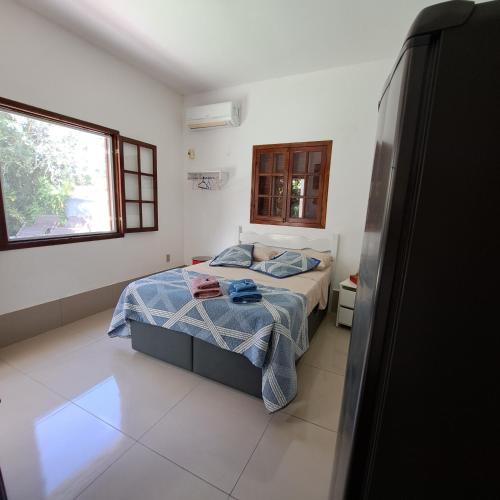 a small bedroom with a bed and a window at Charmosa suíte de Tucuns. in Búzios