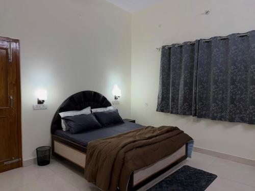 a bedroom with a bed with a black headboard at Palm Stone Villa in Lucknow