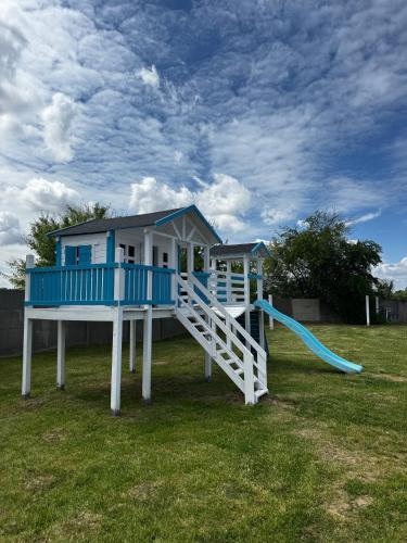 ein blau-weißes Spielhaus mit Rutsche in der Unterkunft Wake Villa in Brwinów