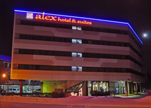 a building with a hotel and suites sign on it at Alex Hotel and Suites Anchorage Airport in Anchorage