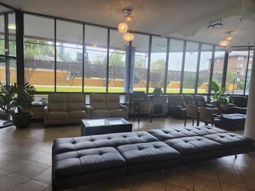 a lobby with a couch and chairs and windows at Alex Hotel and Suites Anchorage Airport in Anchorage