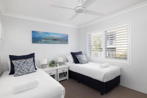 a bedroom with two beds and a window at Sundeck Shoal Bay Ground floor with views and pool access in Shoal Bay