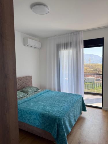 a bedroom with a bed and a large window at Moderan 80m2 apartman - 2 kupatila - terasa - blizu centra i plaze in Bar