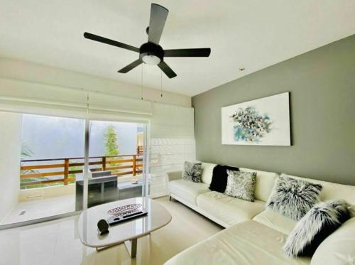 a living room with a couch and a ceiling fan at Grand Blue Playa in Playa del Carmen