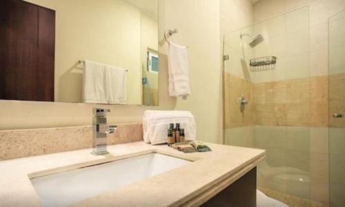 a bathroom with a sink and a shower at Grand Blue Playa in Playa del Carmen