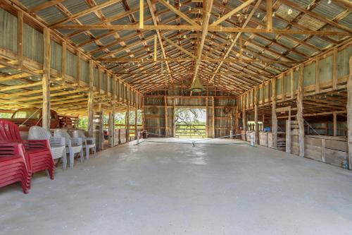 a large building with a large room with red chairs at Live Oak Ranch in Spring Branch