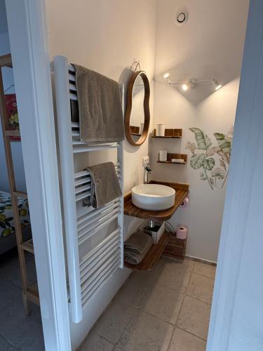 a bathroom with a sink and a toilet and towels at La Fontaine du Soleil in Salernes