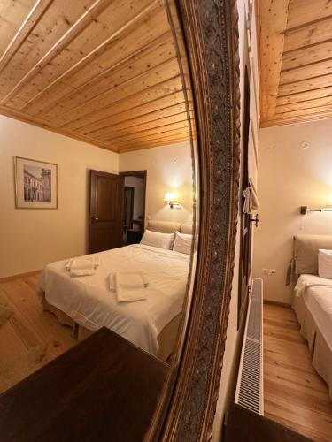 a mirror reflection of a bed in a bedroom at Nostalgia Guesthouse Arachova in Arachova