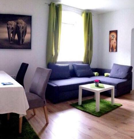 ein Wohnzimmer mit einem blauen Sofa und einem Tisch in der Unterkunft Alpenaquarium Grüblsee - FEWO Monika in Vordernberg