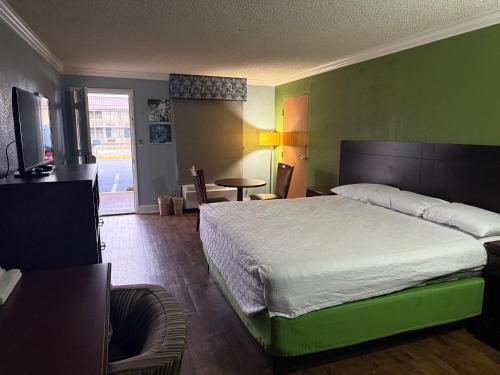 a bedroom with a large bed with a green wall at Soho inn & suites in Perry