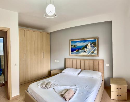 a bedroom with a bed and a painting on the wall at Beach Apartments Durres in Durrës