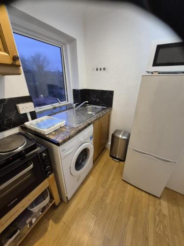 a kitchen with a sink and a washing machine at Self-contained Studio near Tottenham Hotspurs stadium in London