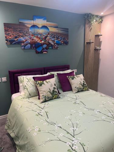 a bedroom with a large bed with two paintings on the wall at The Ivy in Marston Green