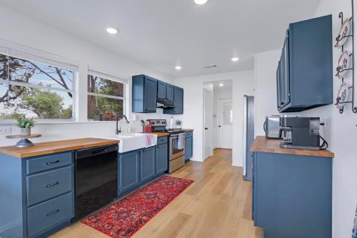 a kitchen with blue cabinets and a sink at Lomax Lookout in Wimberley