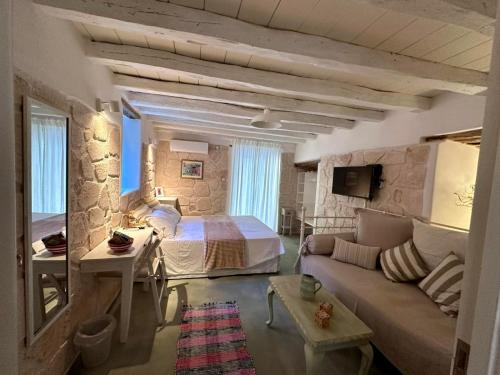 a bedroom with a bed and a couch in a room at Stasa Aegina in Egina