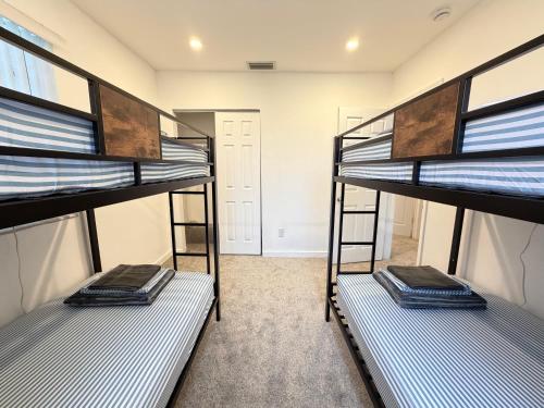 three bunk beds in a room with a hallway at Bek's Hostel in Hallandale Beach