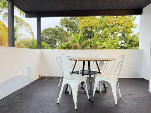 a table and four chairs on a patio at Bek's Hostel in Hallandale Beach