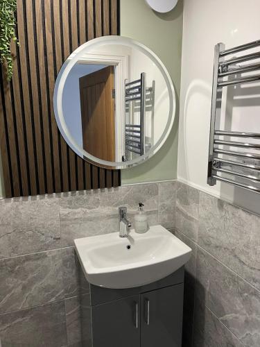 a bathroom with a sink and a mirror at The Ivy in Marston Green