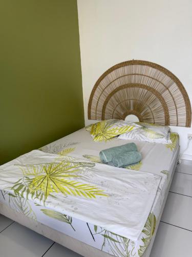 a bed in a room with a green wall at Appartement 3 chambres récemment rénové in Les Abymes