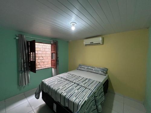 a bedroom with a bed in a room with a window at Quarto Ilha do amor in Santarém