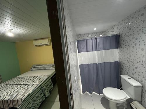 a small room with two beds and a toilet at Quarto Ilha do amor in Santarém