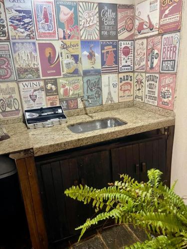 a bathroom counter with a sink and a wall of stickers at Pousada Recanto dos Colibris in Guarapari